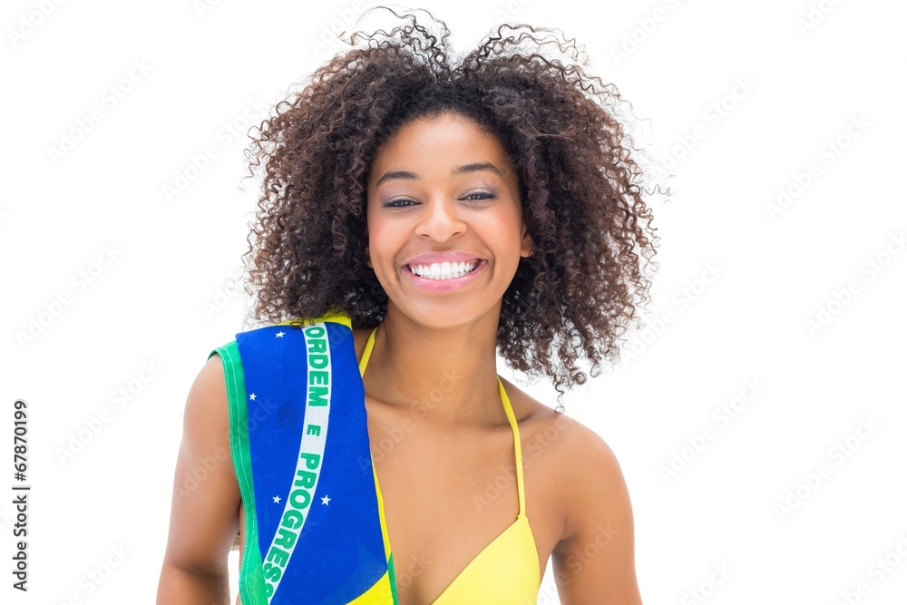 Fit girl in yellow bikini holding brazil flag smiling at camera Fit girl in yellow bikini holding brazil flag smiling at camera