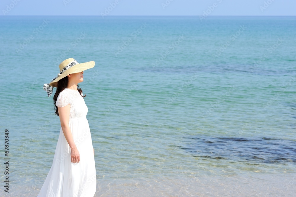 海と白いワンピースを着た女性
