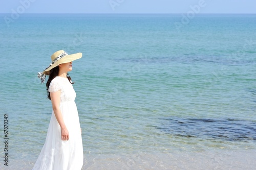 海と白いワンピースを着た女性