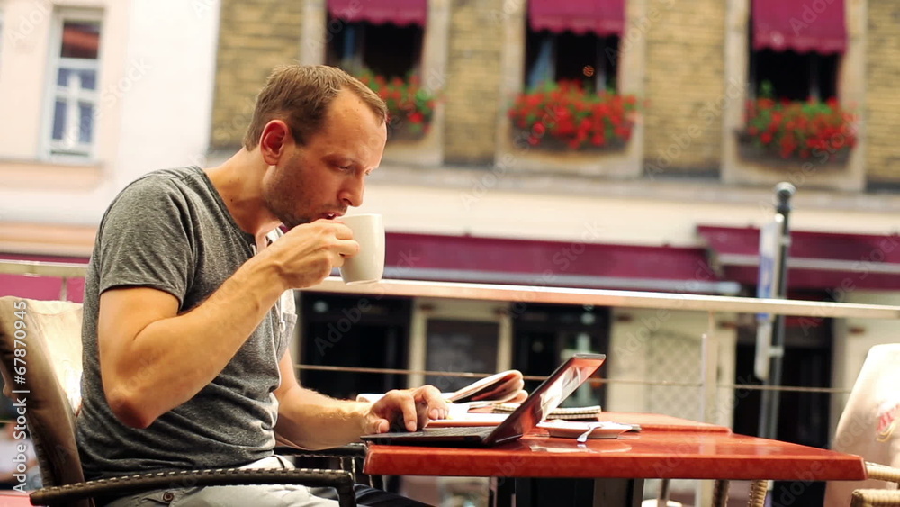 Man working on laptop, eating lunch in restaurant Man working on laptop, eating lunch in restaurant
