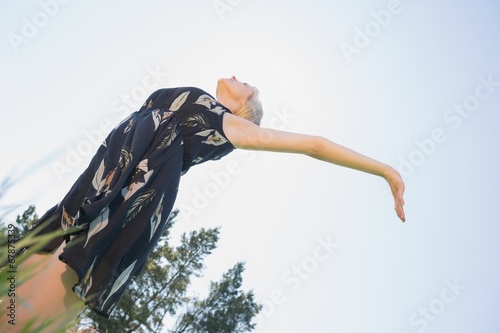 Pretty blonde in sundress standing with arms out photo