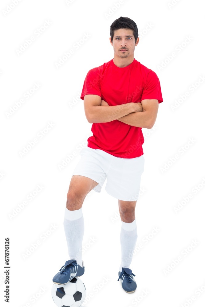 Football player in red standing with ball