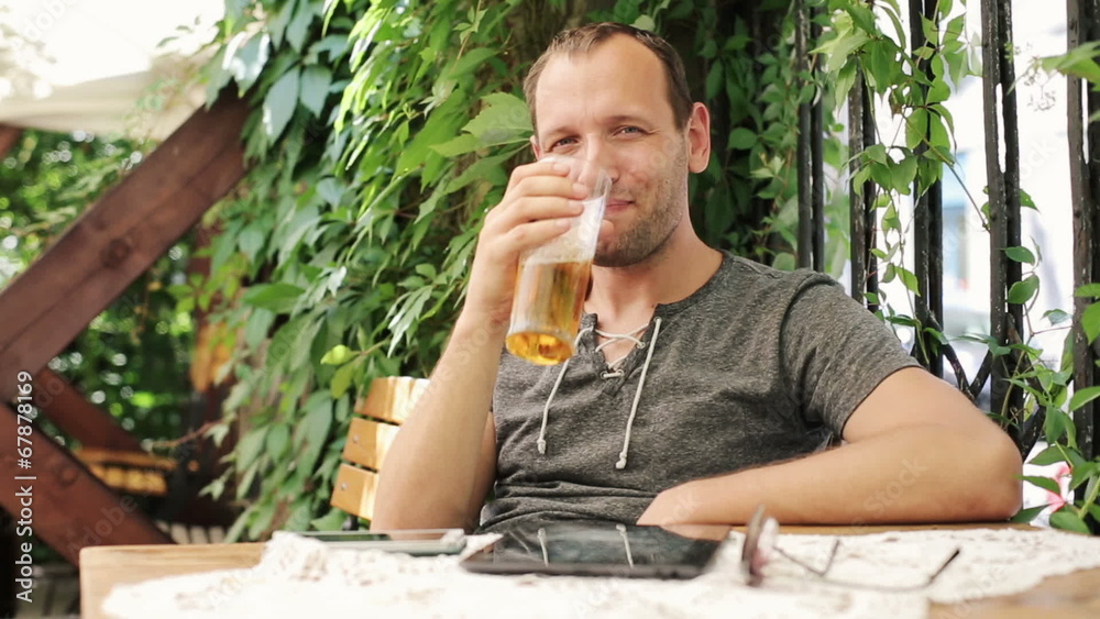 Young man raising toast with beer to camera