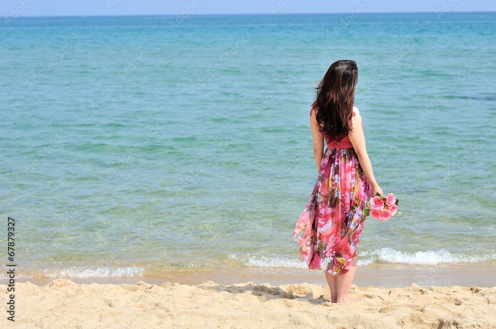 海に向かって佇むピンクのワンピースを着た女性 海に向かって佇むピンクのワンピースを着た女性