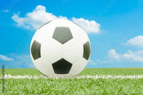 Soccer ball on the field with blue sky.