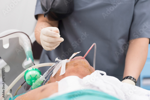 anesthesia nurse use suction suck sputum in oral cavity photo