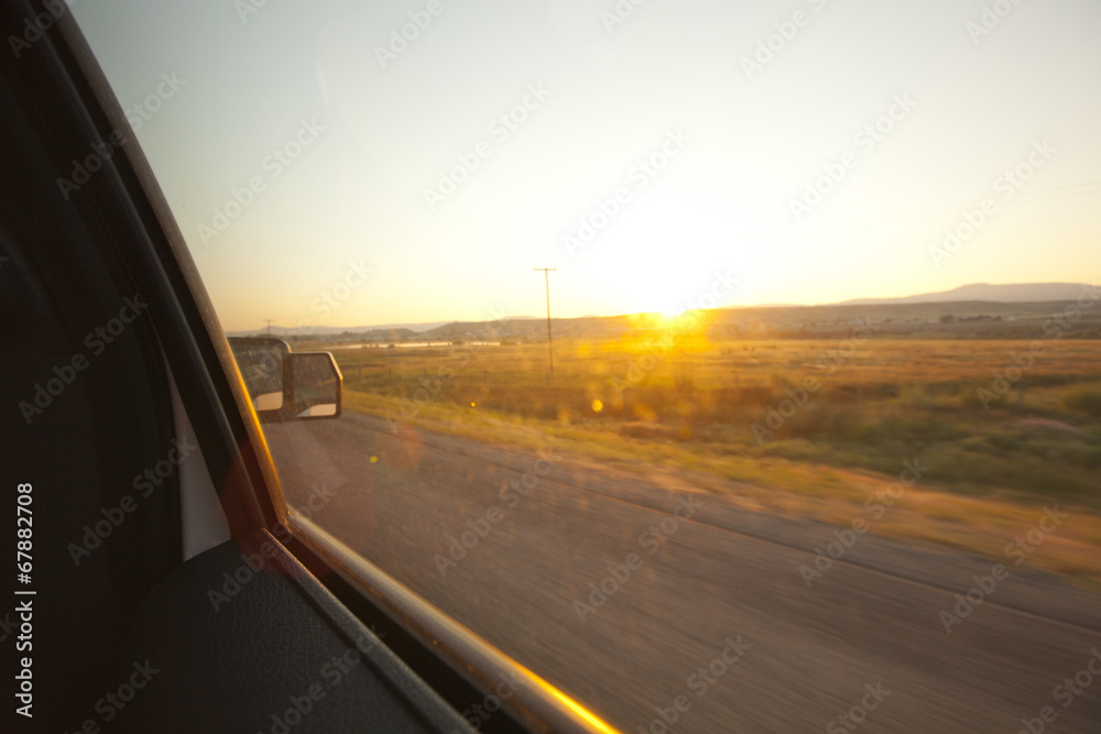 Sunrise out the window of a moving vehicle.