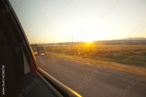 Sunrise out the window of a moving vehicle.