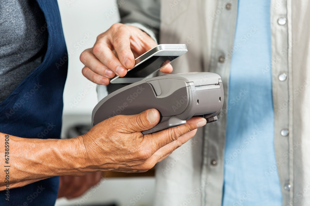 Salesman Accepting Payment Through NFC Technology Salesman Accepting Payment Through NFC Technology
