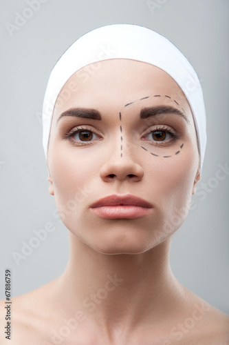 Beautiful young woman with perforation lines on her face before