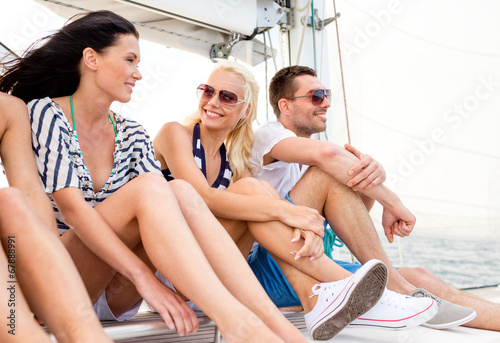 smiling friends sitting on yacht deck