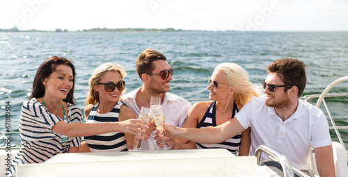 smiling friends with glasses of champagne on yacht © Syda Productions