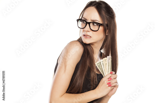 stingy beautiful woman holding her money photo