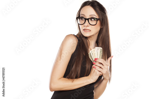 stingy beautiful woman holding her money