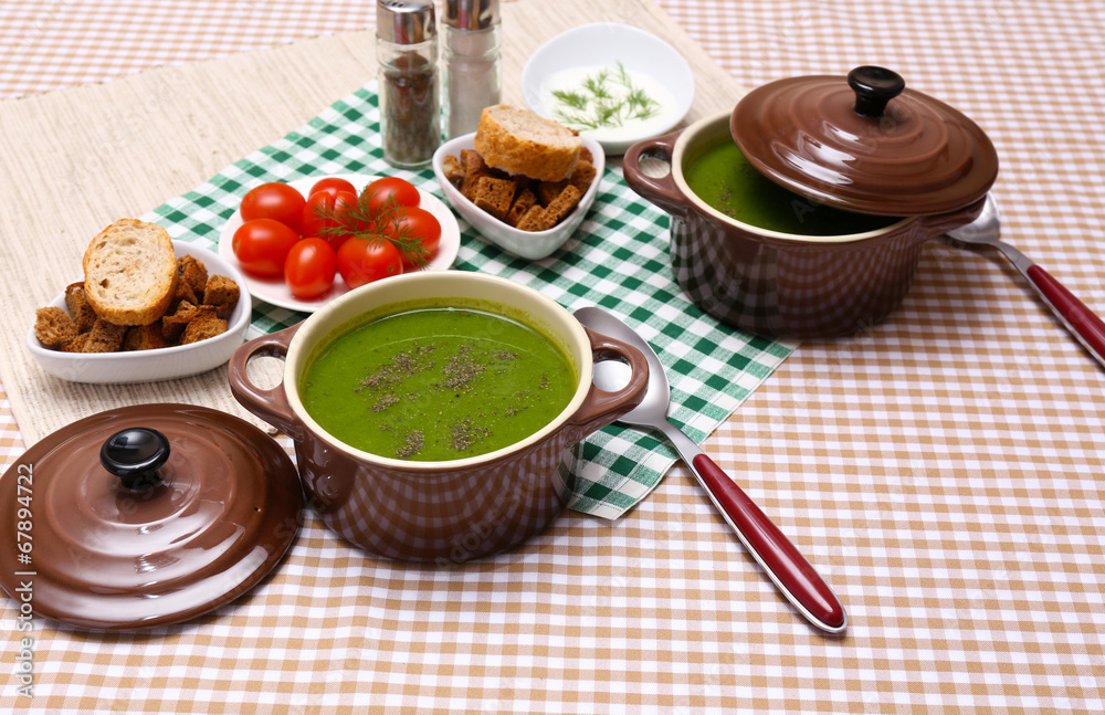 Tasty soup in saucepans on tablecloth, close up Tasty soup in saucepans on tablecloth, close up