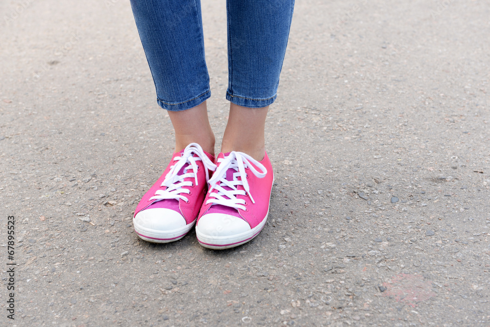 Pink sneakers on girl legs outdoors Pink sneakers on girl legs outdoors