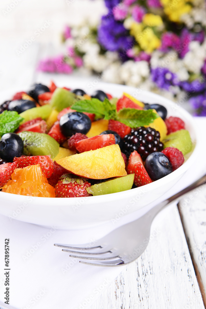 Delicious fruits salad in plate on table close-up Delicious fruits salad in plate on table close-up