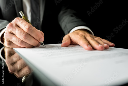 Businessman signing a paper document photo