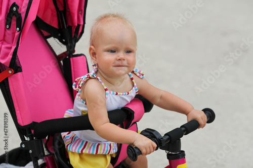 Cute baby girl riding her first bicycle