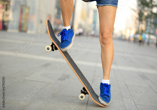 woman skateboarder legs jumping in city photo