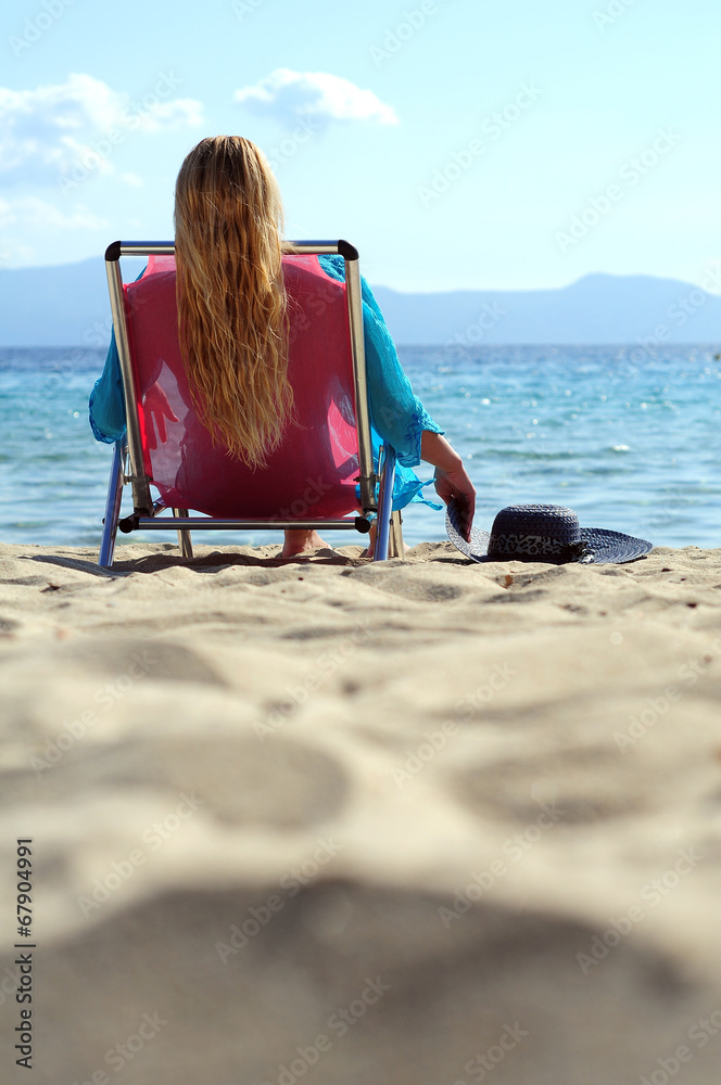 Woman lying deck chair beach