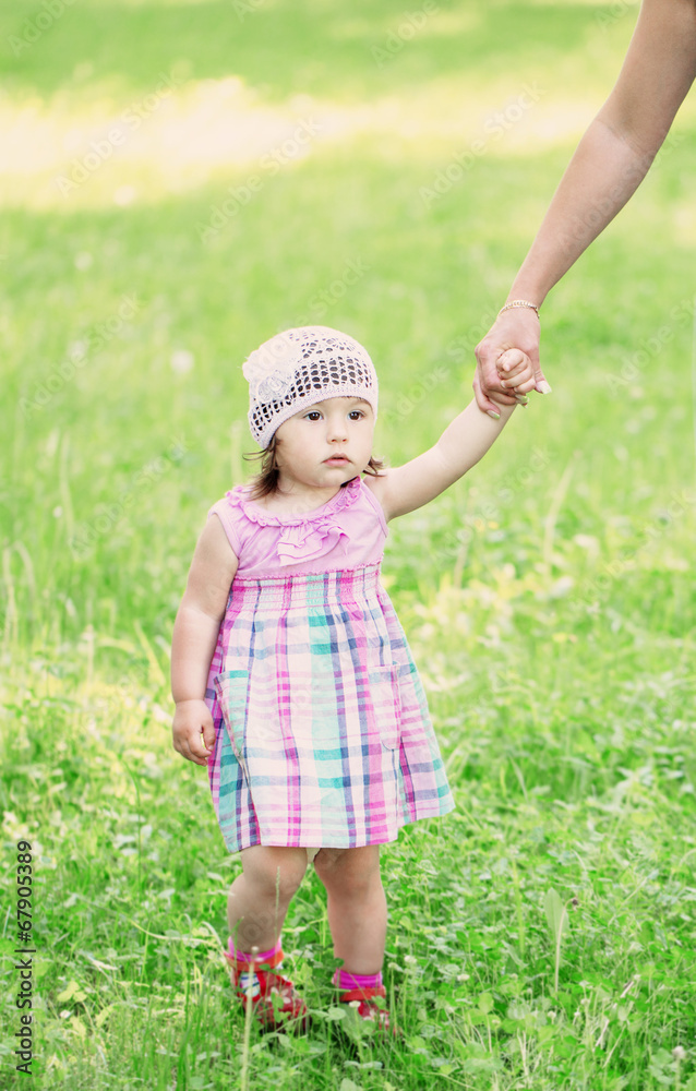 little girl walking holding mother hand in park little girl walking holding mother hand in park