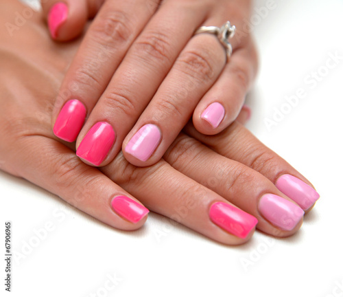 Women s hands with a colored pink nail polish