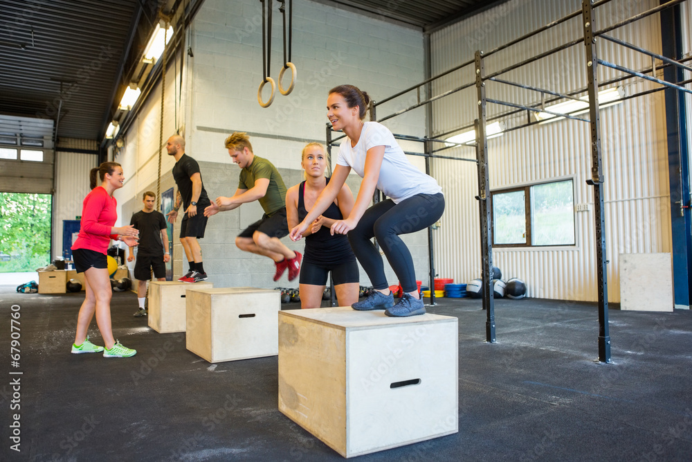Athletes Doing Box Jumps At Gym - obrazy, fototapety, plakaty 