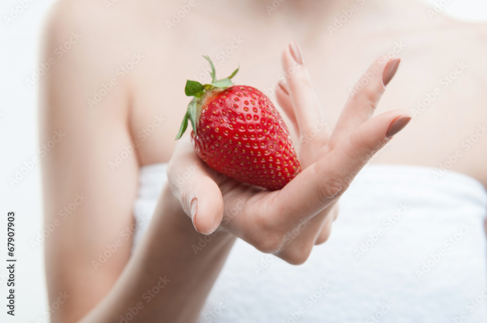 Obraz premium Portrait of young attractive woman in towel with strawberry
