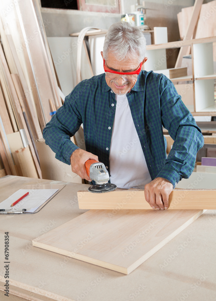 Carpenter Using Electric Sander At Table Carpenter Using Electric Sander At Table