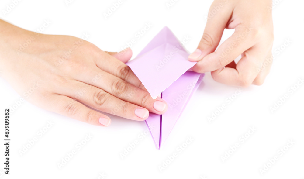Hands making origami toy, close up, isolated on white Hands making origami toy, close up, isolated on white