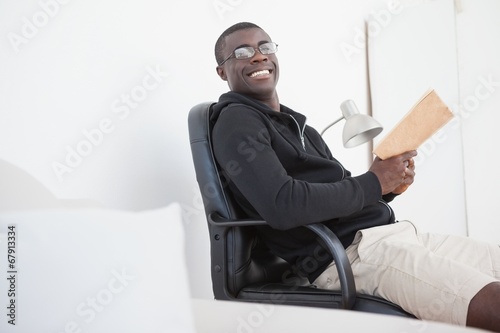 Casual man sitting on swivel chair reading a book
