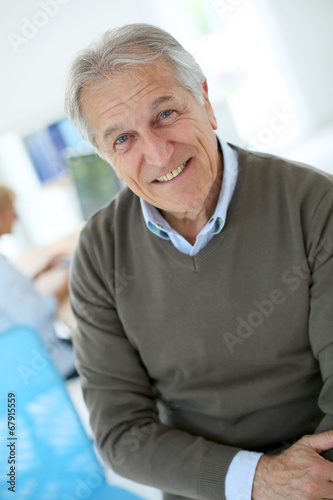 Smiling senior man sitting in office