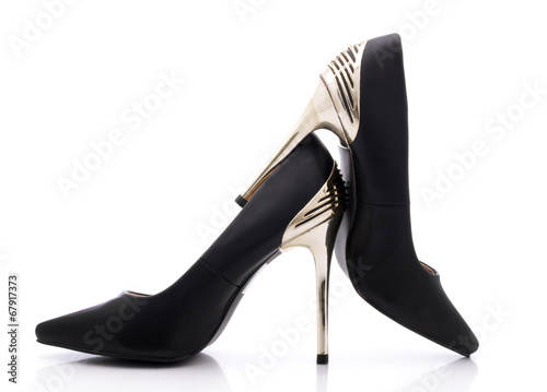 Sexy black shoes with high gold heels on white background