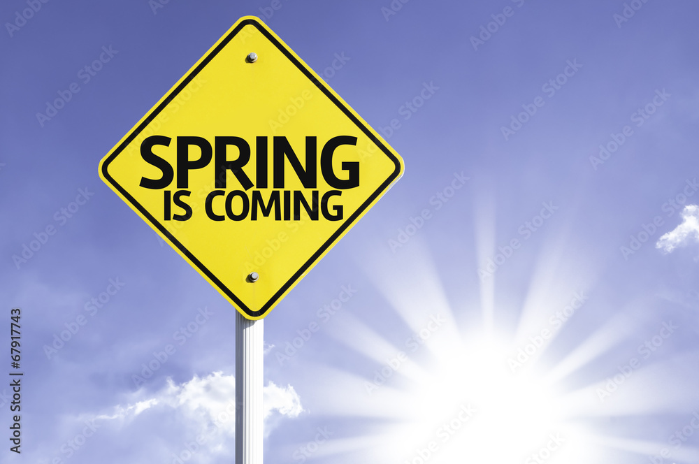Spring is Coming road sign with sun background Spring is Coming road sign with sun background