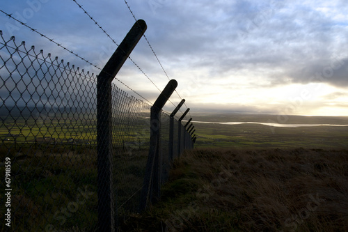 barbed wire fencing and scenic view photo