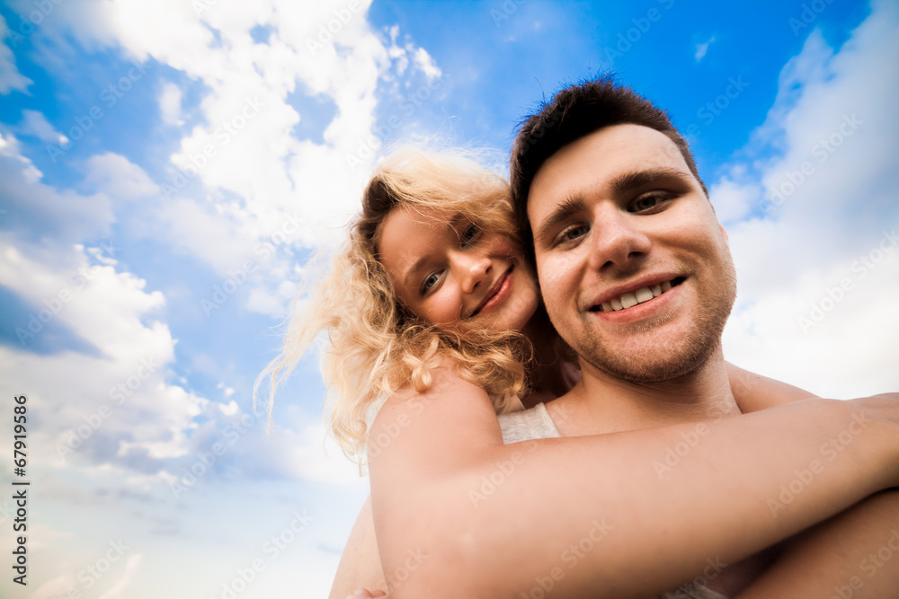 The couple smiles against a background sky The couple smiles against a background sky