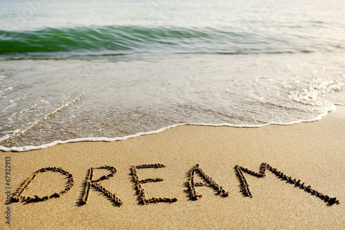 word dream written in the sand - positive thinking concept
