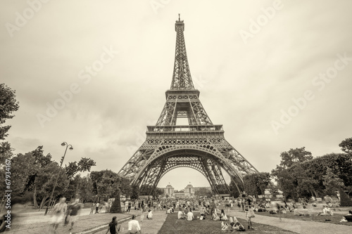 Tourists enjoying Eiffel Tower view from Champs de Mars gardens