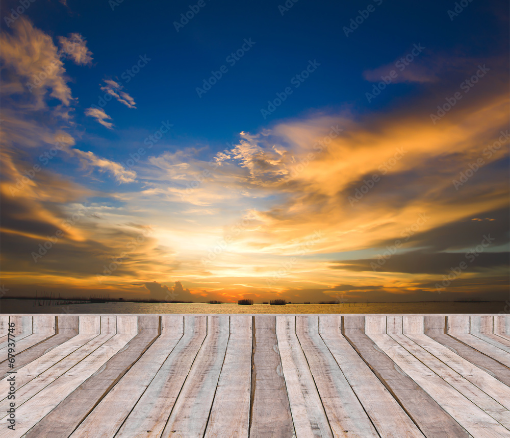 Wood plank as a pier or deck on blue sea water and sky