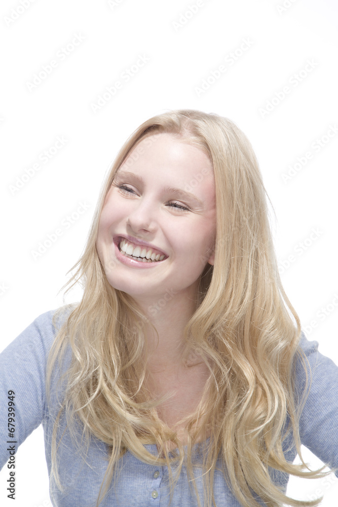 Junge blonde Frau lächelt gegen weisser Hintergrund