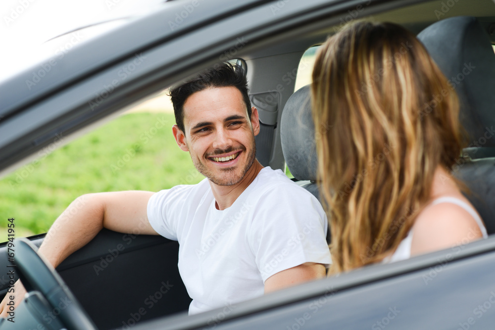 happy young couple driving new car on holiday trip in summer