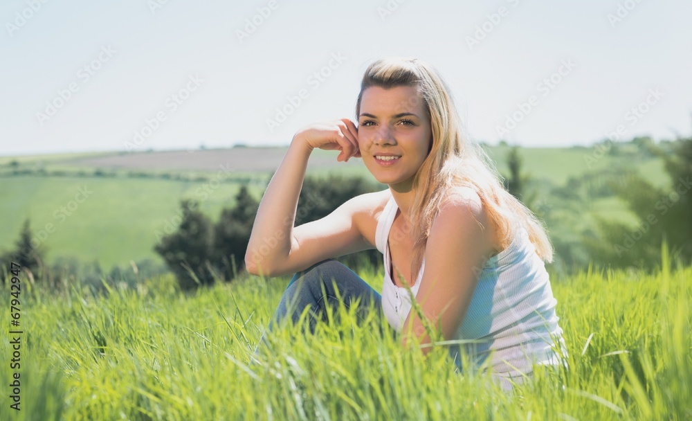 Pretty blonde smiling at camera sitting on grass Pretty blonde smiling at camera sitting on grass