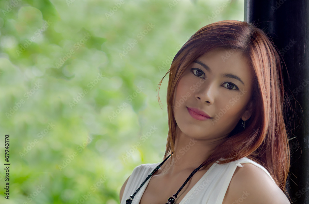Fototapeta premium Beautiful happy young woman in a park