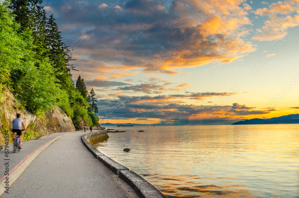 Sunset over The Seawall of Vancouver with cyclist in motion