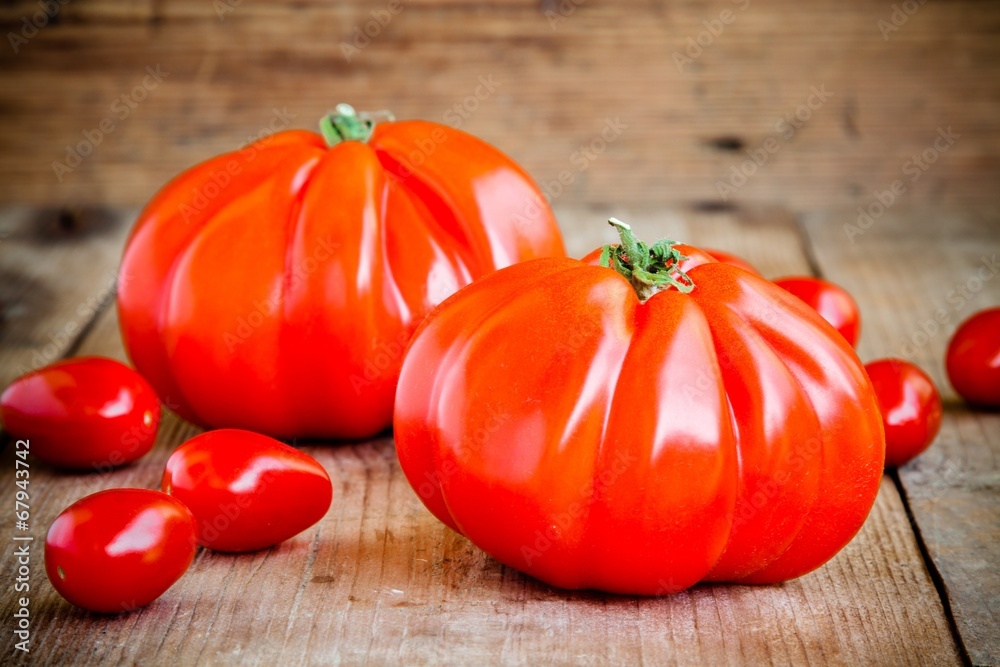 Fresh red heirloom tomatoes on a wooden background Fresh red heirloom tomatoes on a wooden background