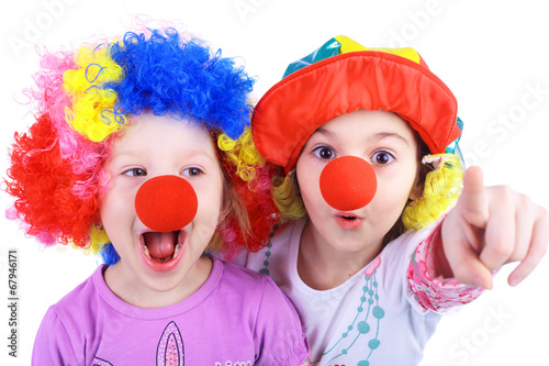 Two kids playing clowns in bright wigs