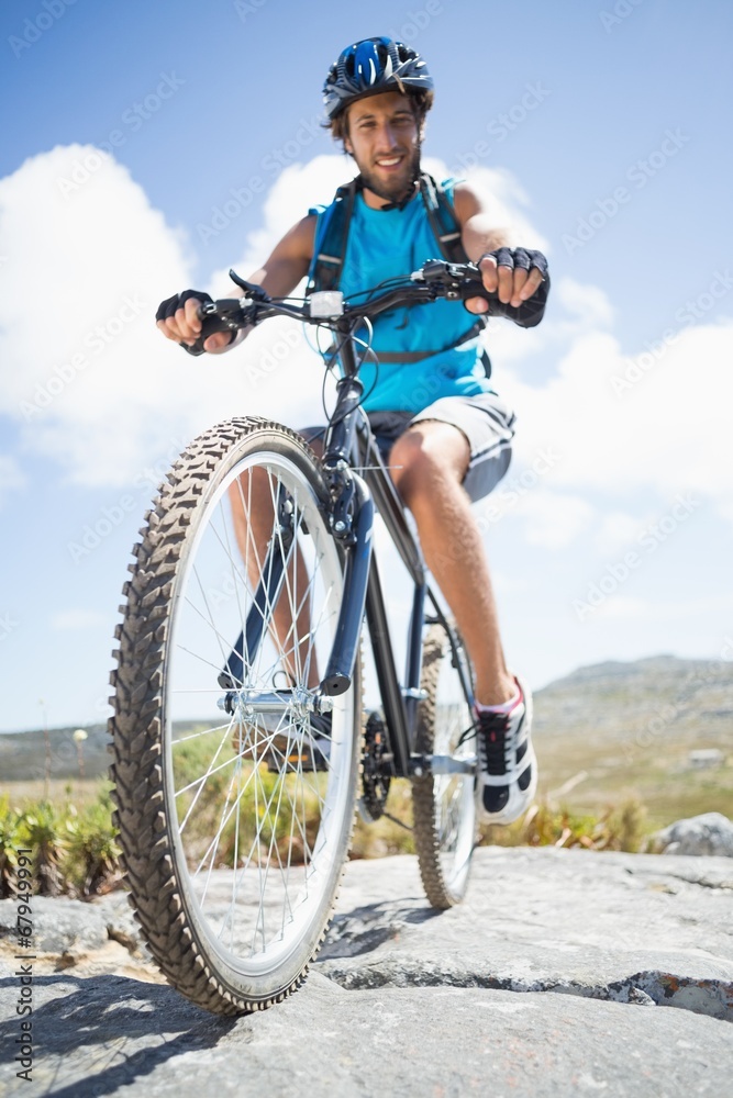 Fit man cycling on rocky terrain