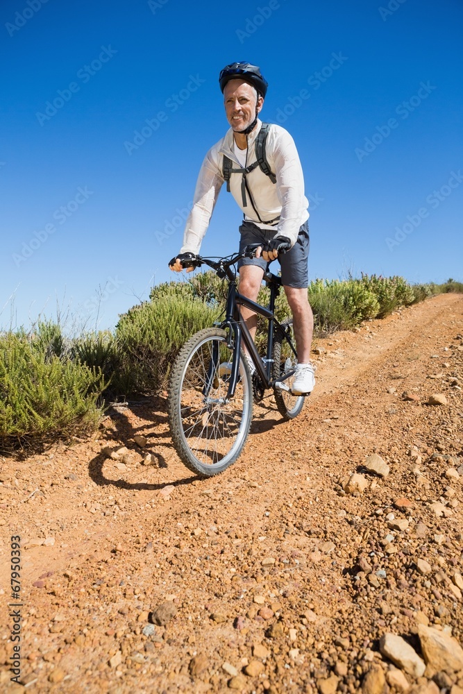 Fit cyclist cycling on country terrain