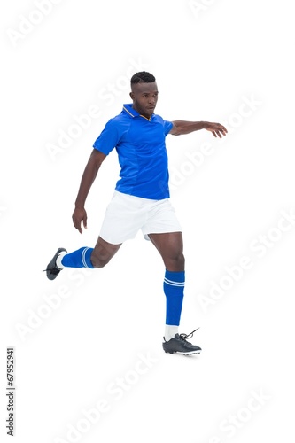 Football player in blue kicking